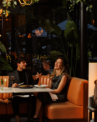 A couple celebrating the holiday season with food and laughter in The Pembroke restaurant, which is taking reservations for Christmas and New Year's Eve.